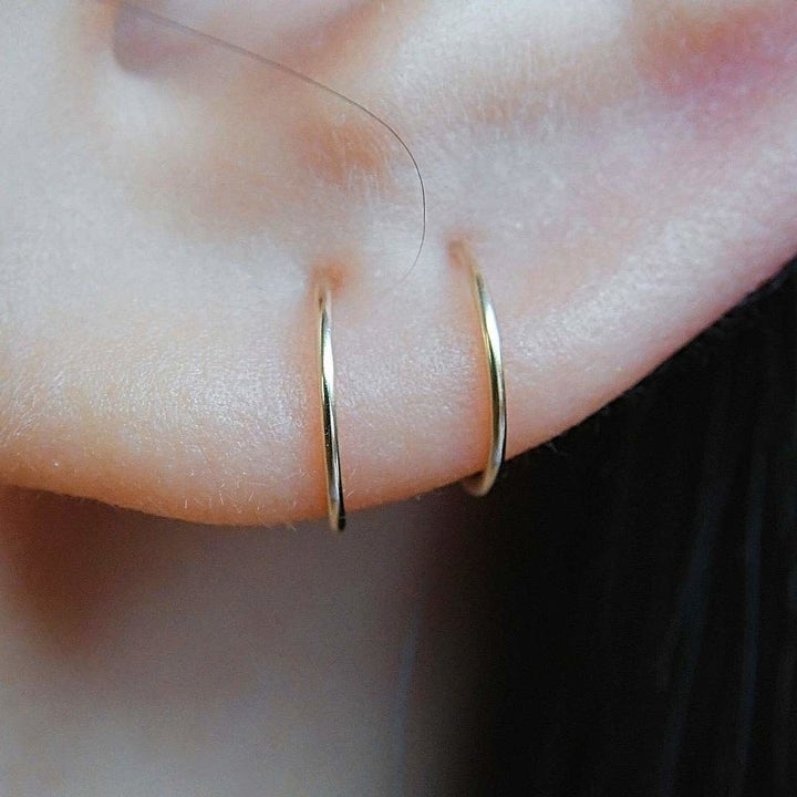 same gold hoops in earlobe piercings