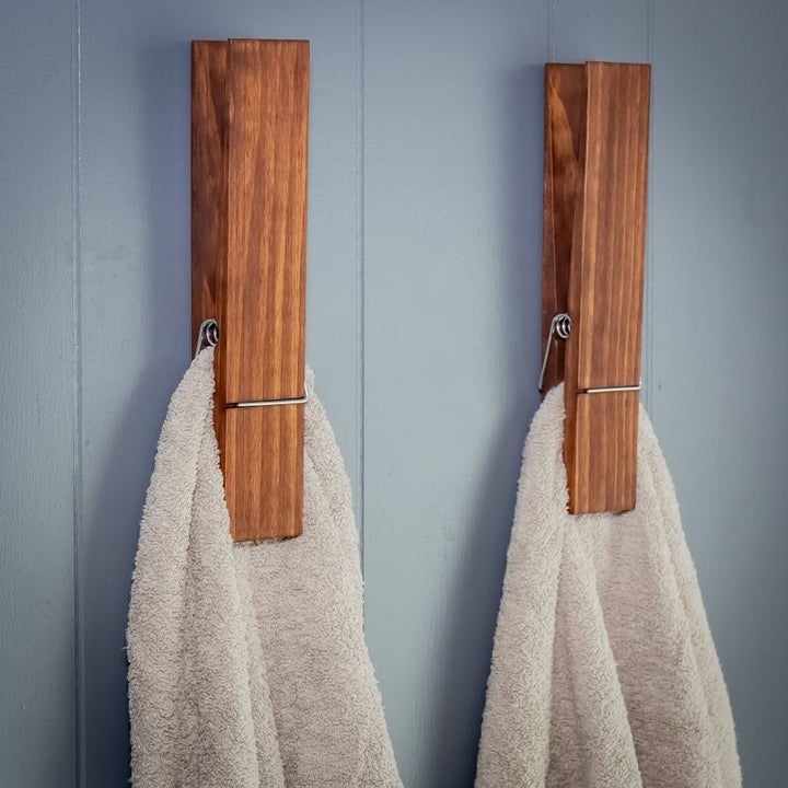 Two jumbo clothespin bathroom towel holders installed on bathroom wall