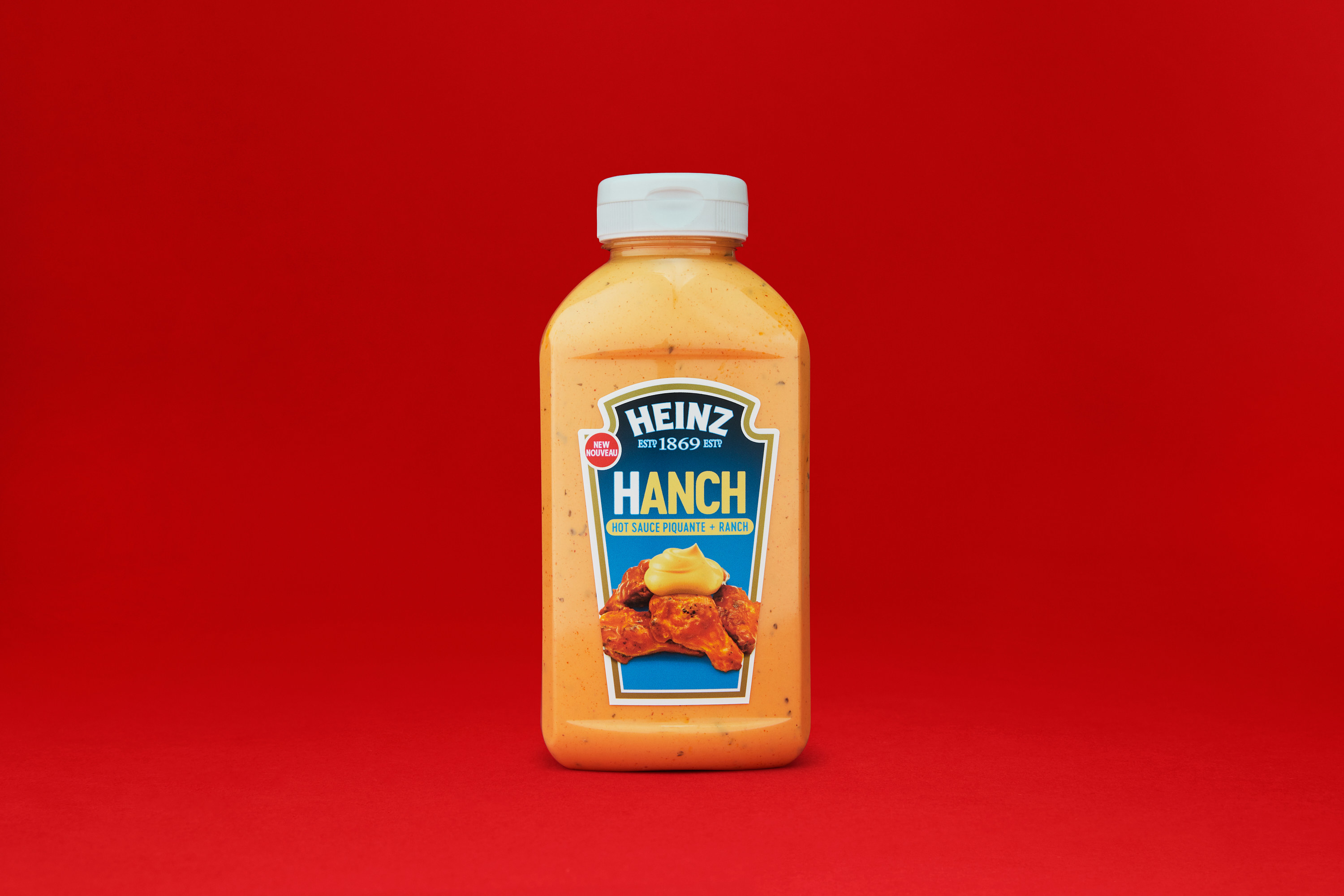 A bottle of Hanch sauce on a red backdrop.