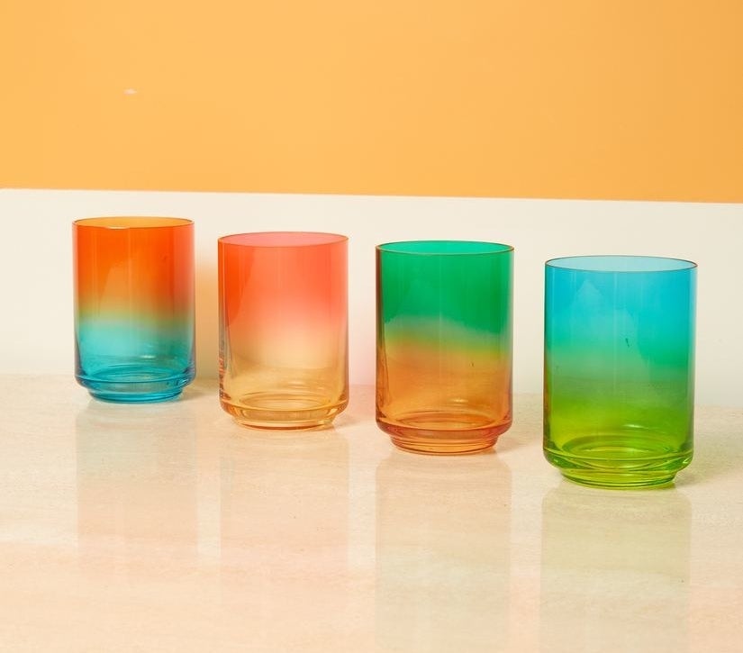 four short glasses in two-different colors — blue/orange, yellow/pink, orange/green, and green/blue