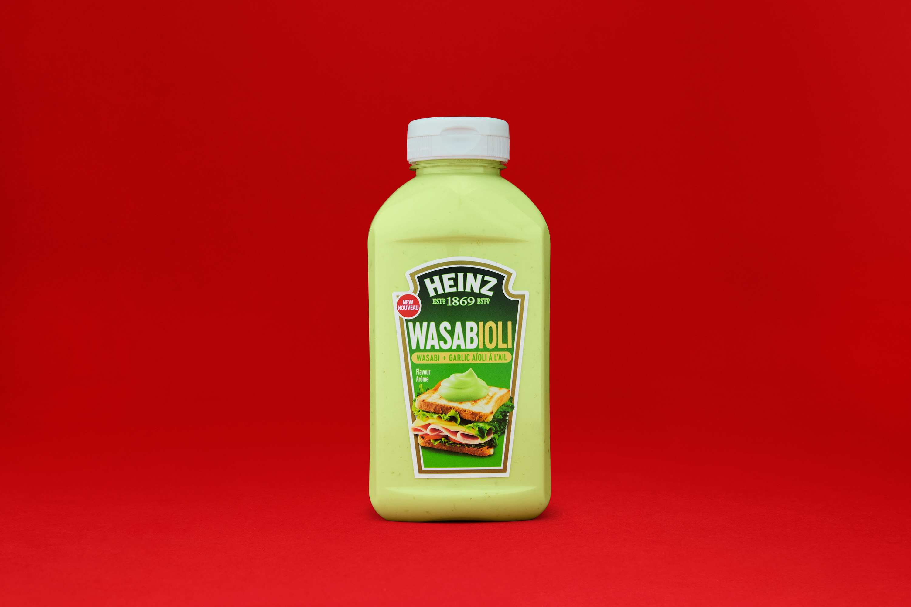 A bottle of Wasabioli sauce on a red backdrop.