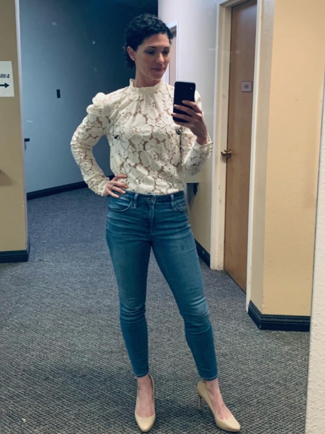 A reviewer wearing the blouse in white with blue jeans