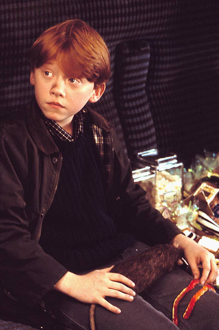 Rupert Grint as Ron Weasley with a rat on his lap in Harry Potter and the Sorcerer&#x27;s Stone