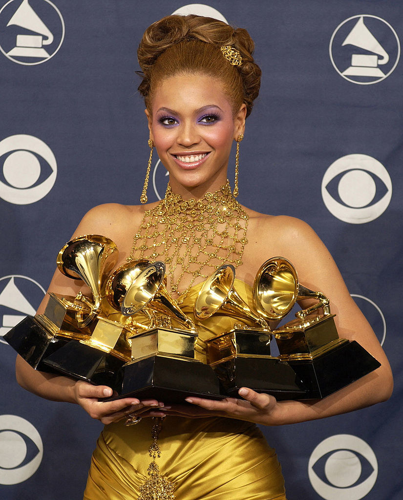Beyonce holding five Grammys in her arms at The 46th Annual GRAMMY Awards