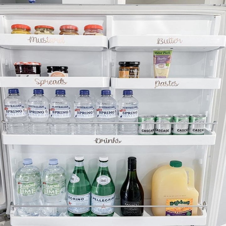 Various labels placed on shelves in a fridge door