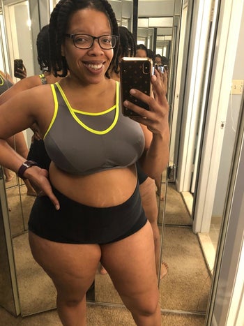 reviewer in the gray and neon yellow sports bra and comfy shorts