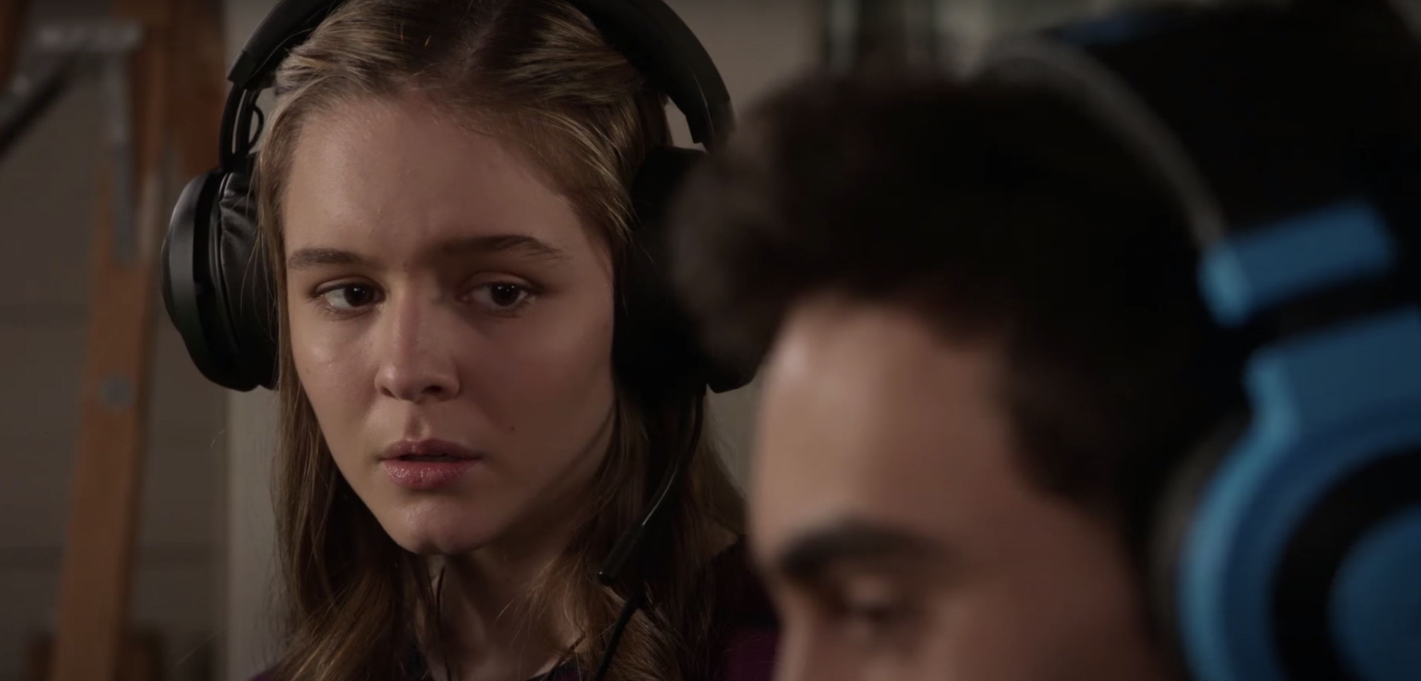 A young woman with a headset on looks upset