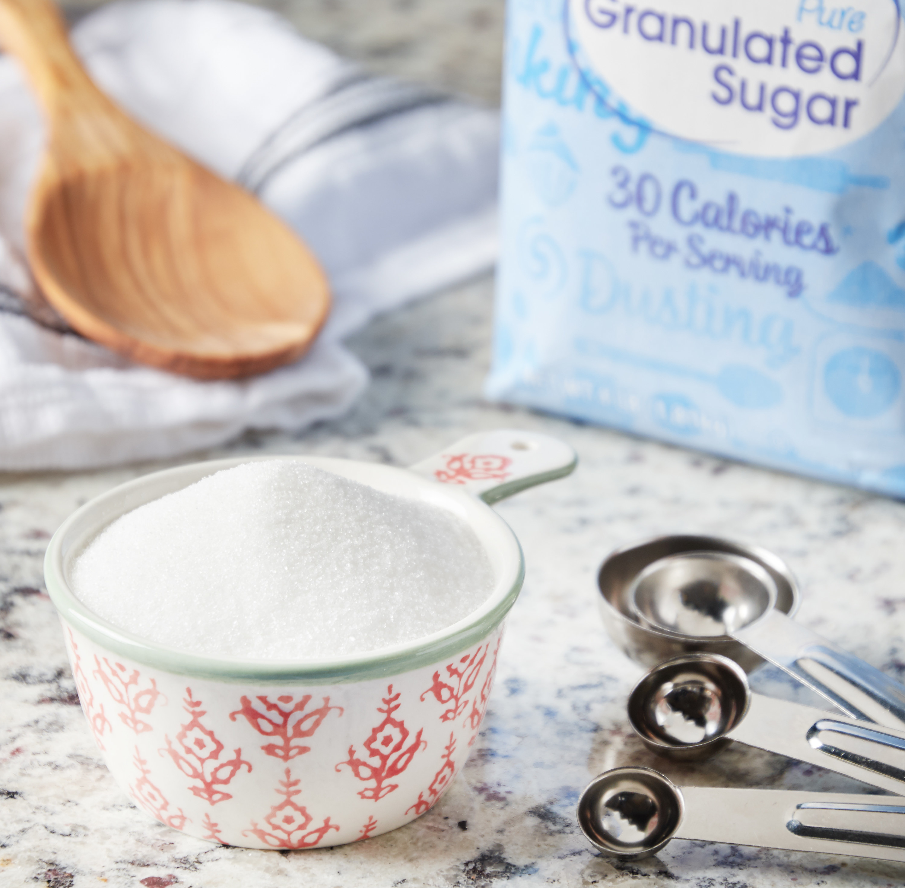 a measuring cup of sugar on a counter