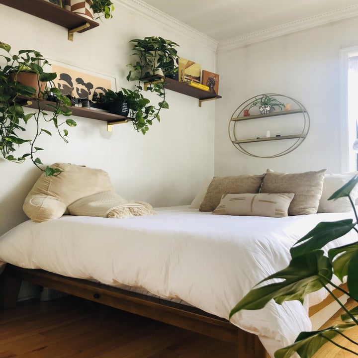 the buzzfeed writer's made bed on the walnut frame with a white linen headboard