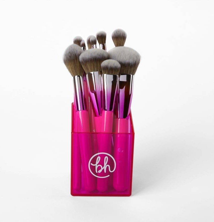 Ten pink ombre makeup brushes standing up in a pink case 