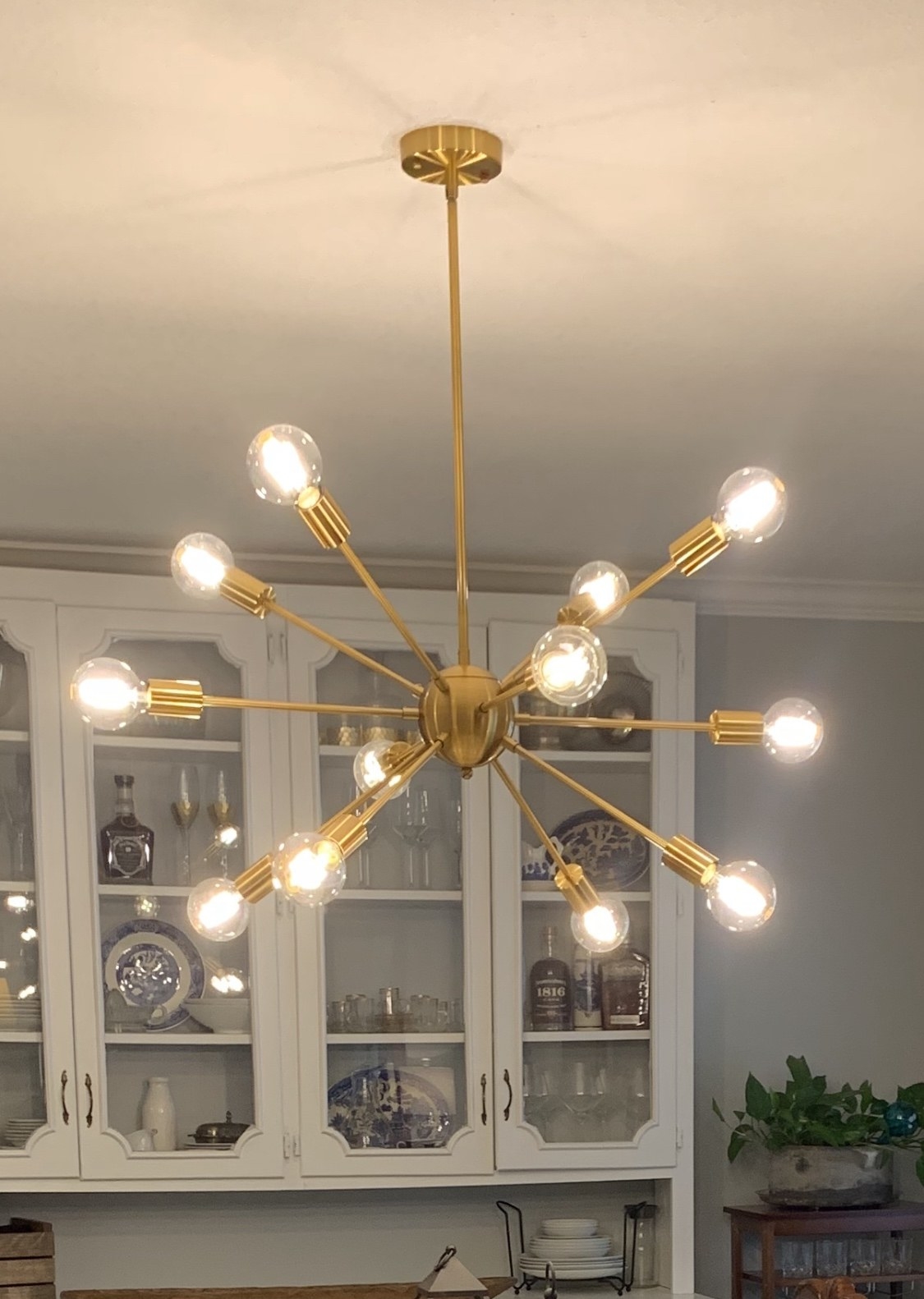 close up reviewer image of the brass 12 light sputnik chandelier hanging in a kitchen