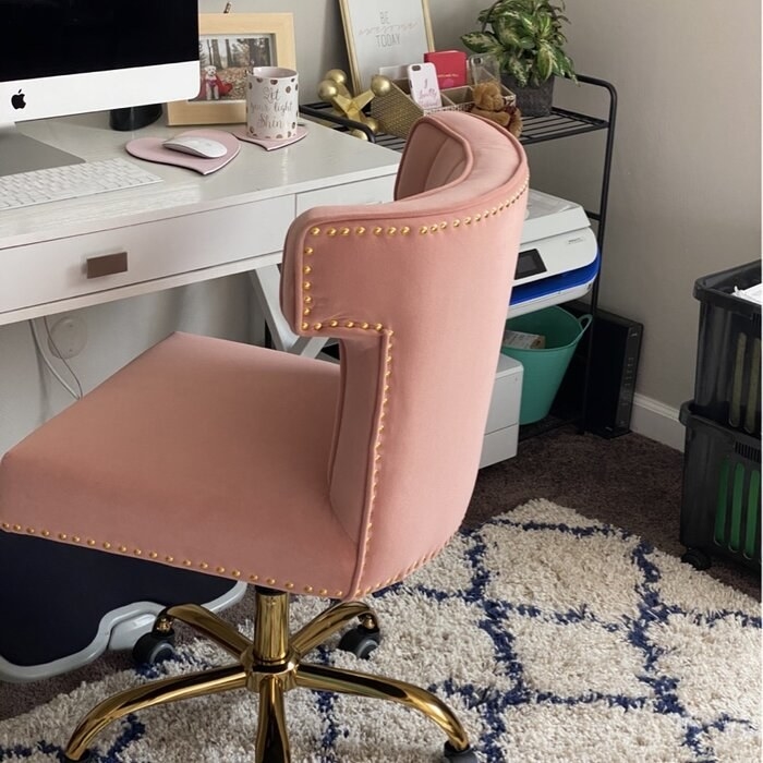 a reviewer&#x27;s pink and gold desk chair