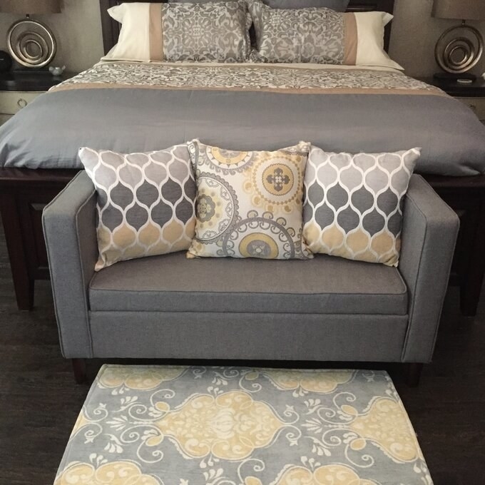 gray bench at the end of a reviewer's bed