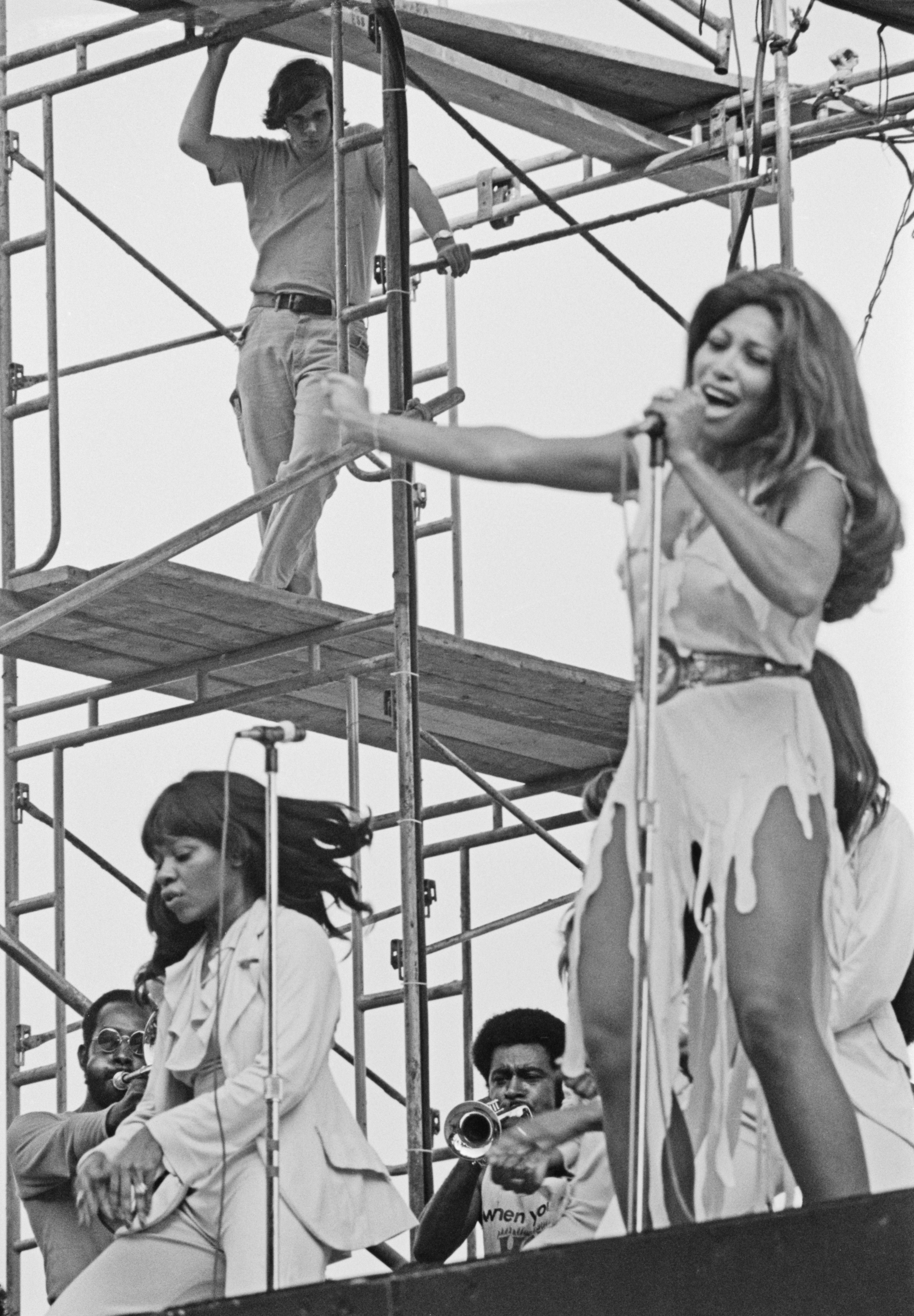 Tina Turner performing onstage with band