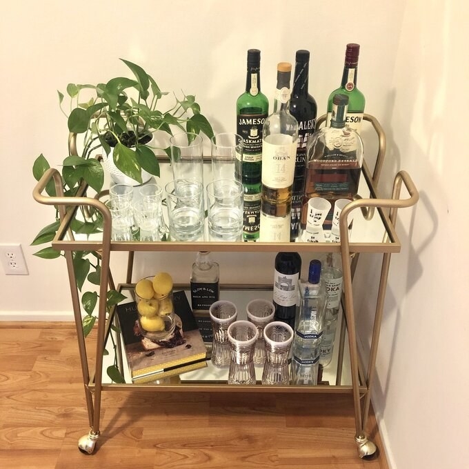 a reviewer&#x27;s photo of the bar cart with glasses and accessories