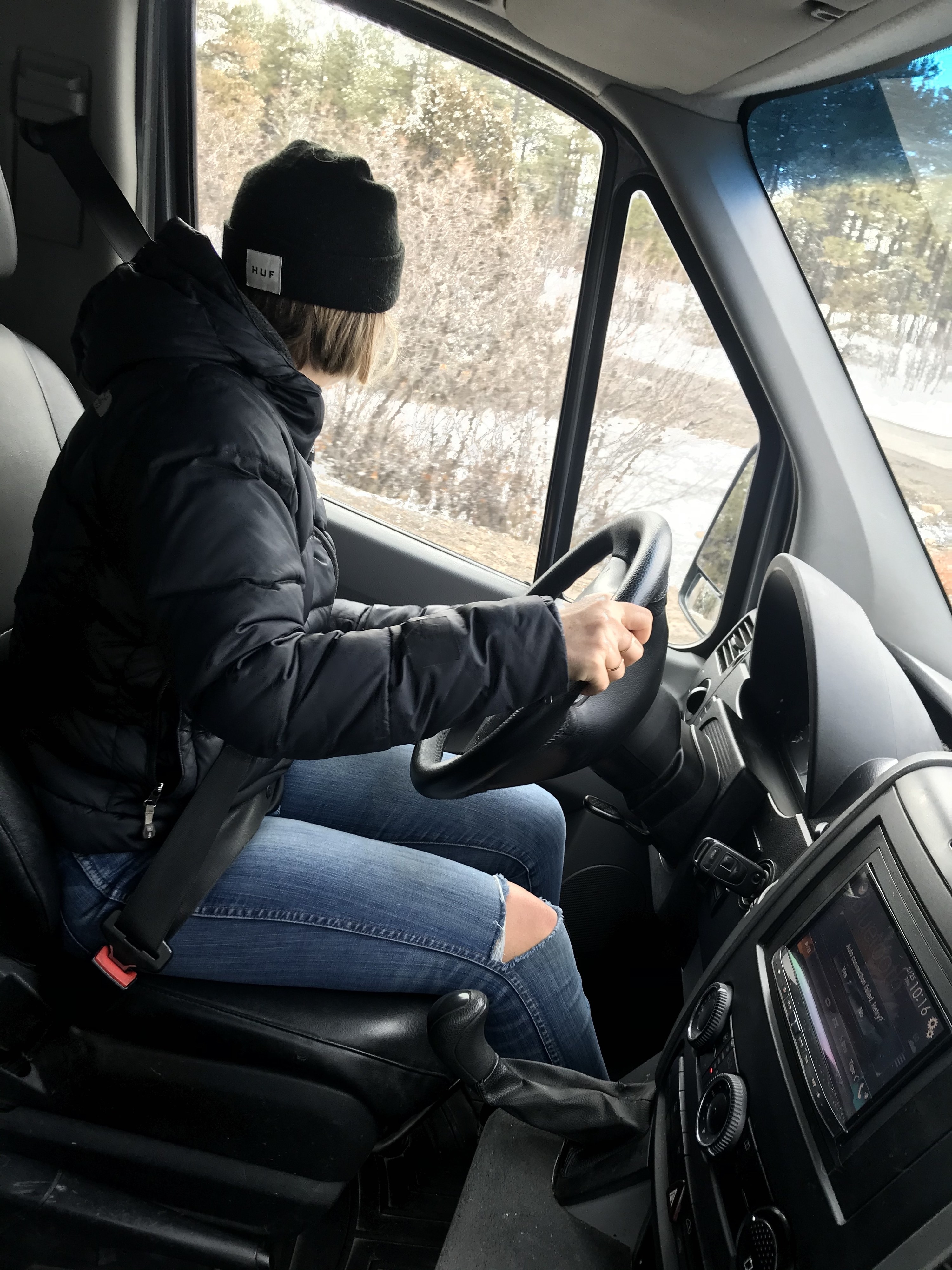 Woman looking over her shoulder while driving a van