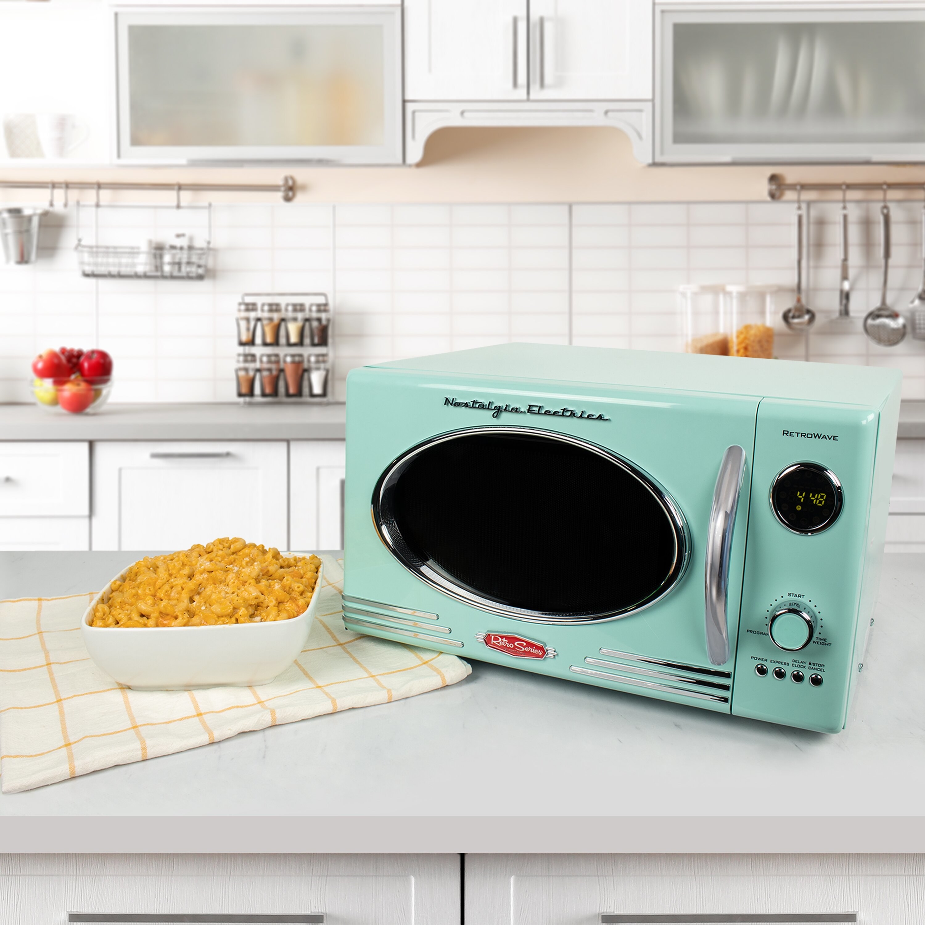 The microwave on a counter next to a bowl of mac and cheese