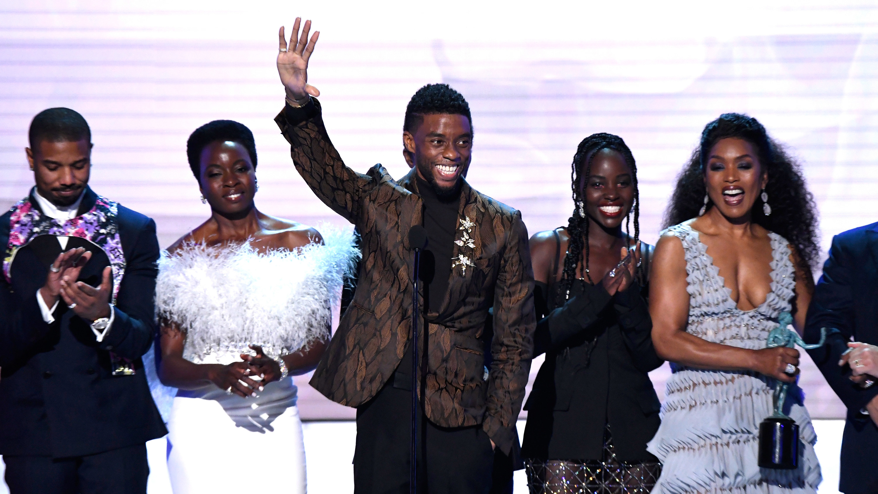 Chadwick waves on stage while surrounded by co-stars 