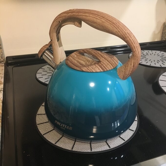 a reviewer&#x27;s aqua blue kettle on a stovetop