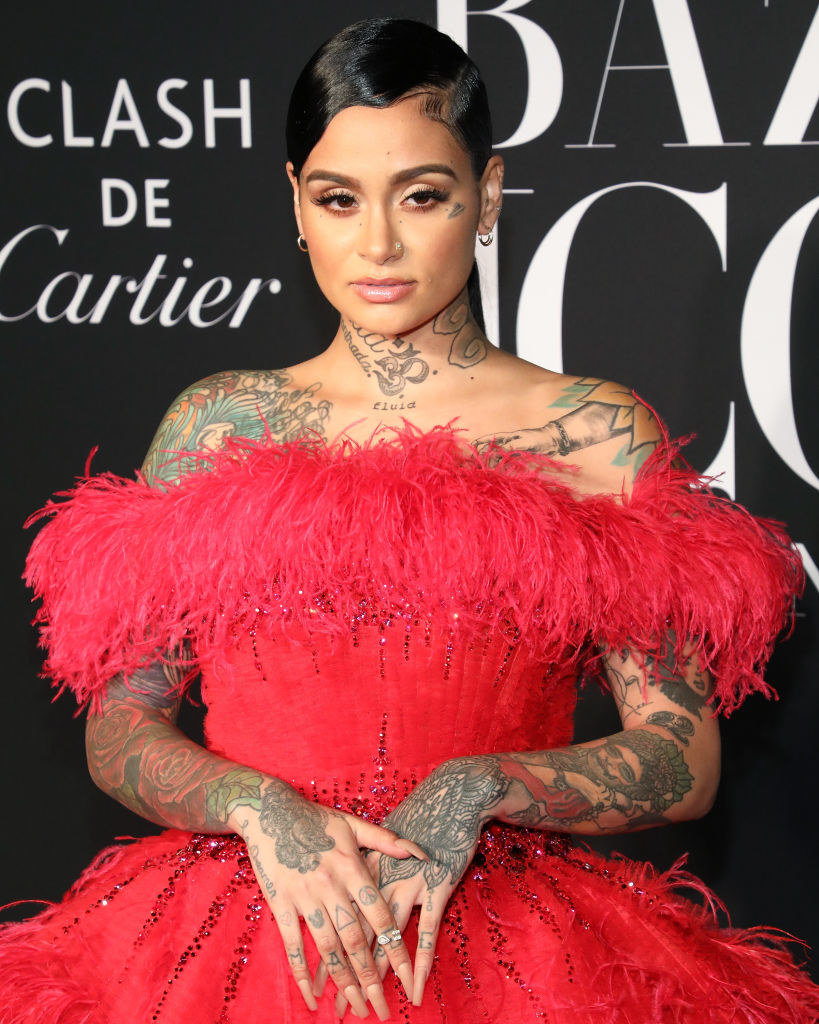 Kehlani posing in a off-the-shoulder feathered gown