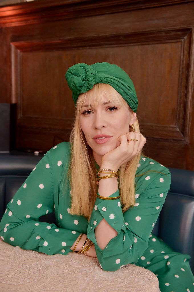 Natasha posing for a photo in a polka dot dress and matching head scarf