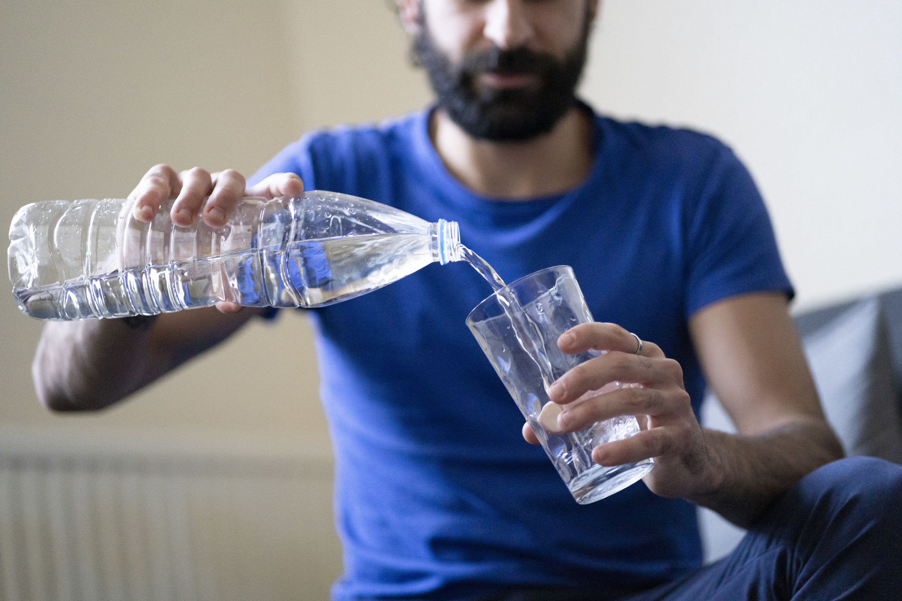 A man pouring water into a glass