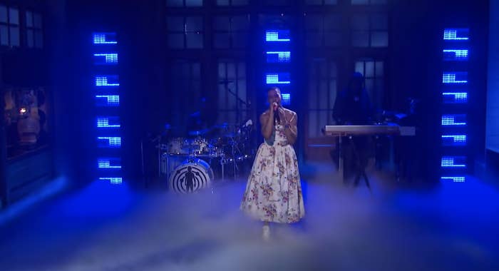 Kid Cudi performs while wearing a long floral-print, spaghetti-strap gown