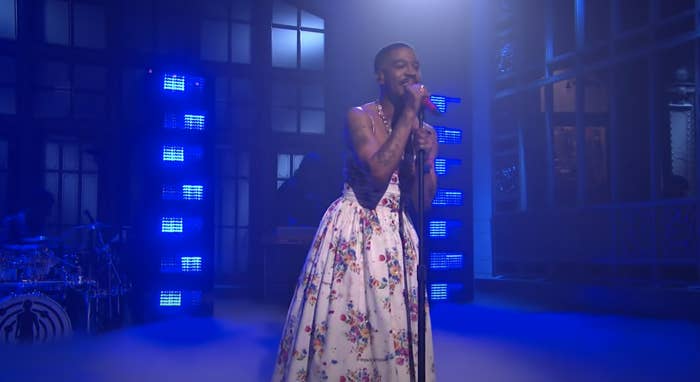 Kid Cudi performs while wearing a long floral-print, spaghetti-strap gown