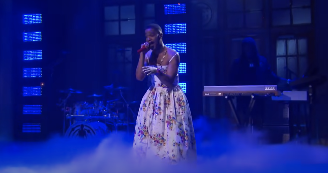 Kid Cudi performs while wearing a long floral-print, spaghetti-strap gown
