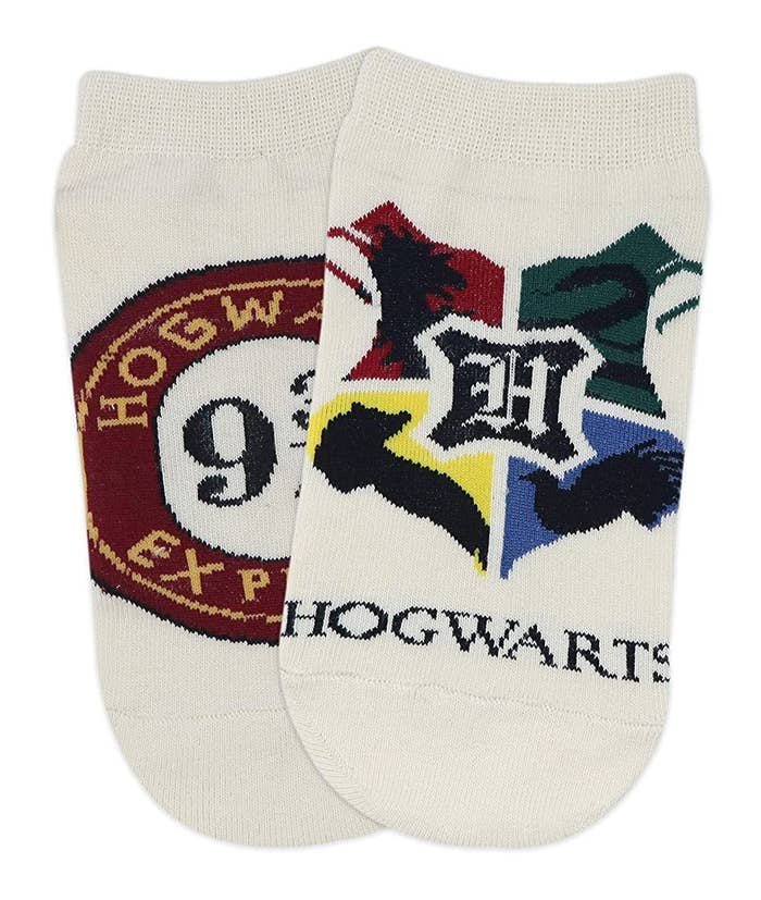 Two white socks. One has the Hogwarts crest on it and the other has the Hogwarts Express logo on it.