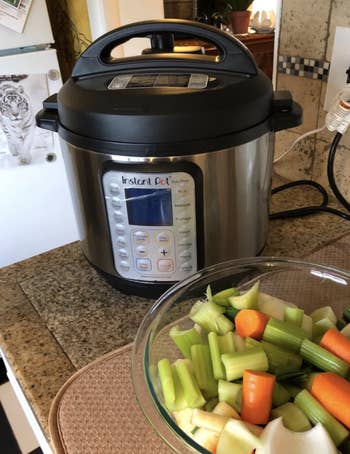 reviewer's pic of the Instant Pot beside a bowl of vegetables