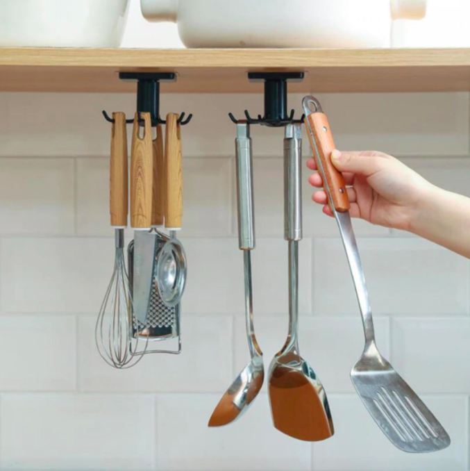 A person removing a spatula from the rotating utensil holder that&#x27;s mounted to the underside of their cupboard