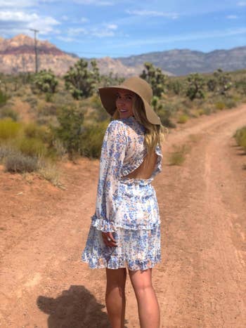 another reviewer wears the A1 white Dokotoo ruffled mini dress on a dirt path