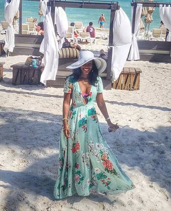 image of reviewer wearing the A green milumia floral maxi dress at a sandy beach resort