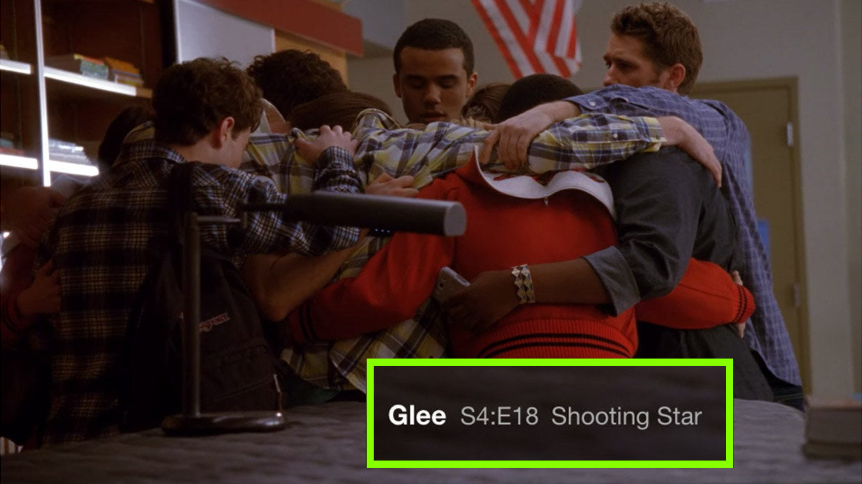 The glee club huddling and comforting each other in the choir room; a screenshot of the episode title, &quot;Shooting Star,&quot; in the lower righthand corner