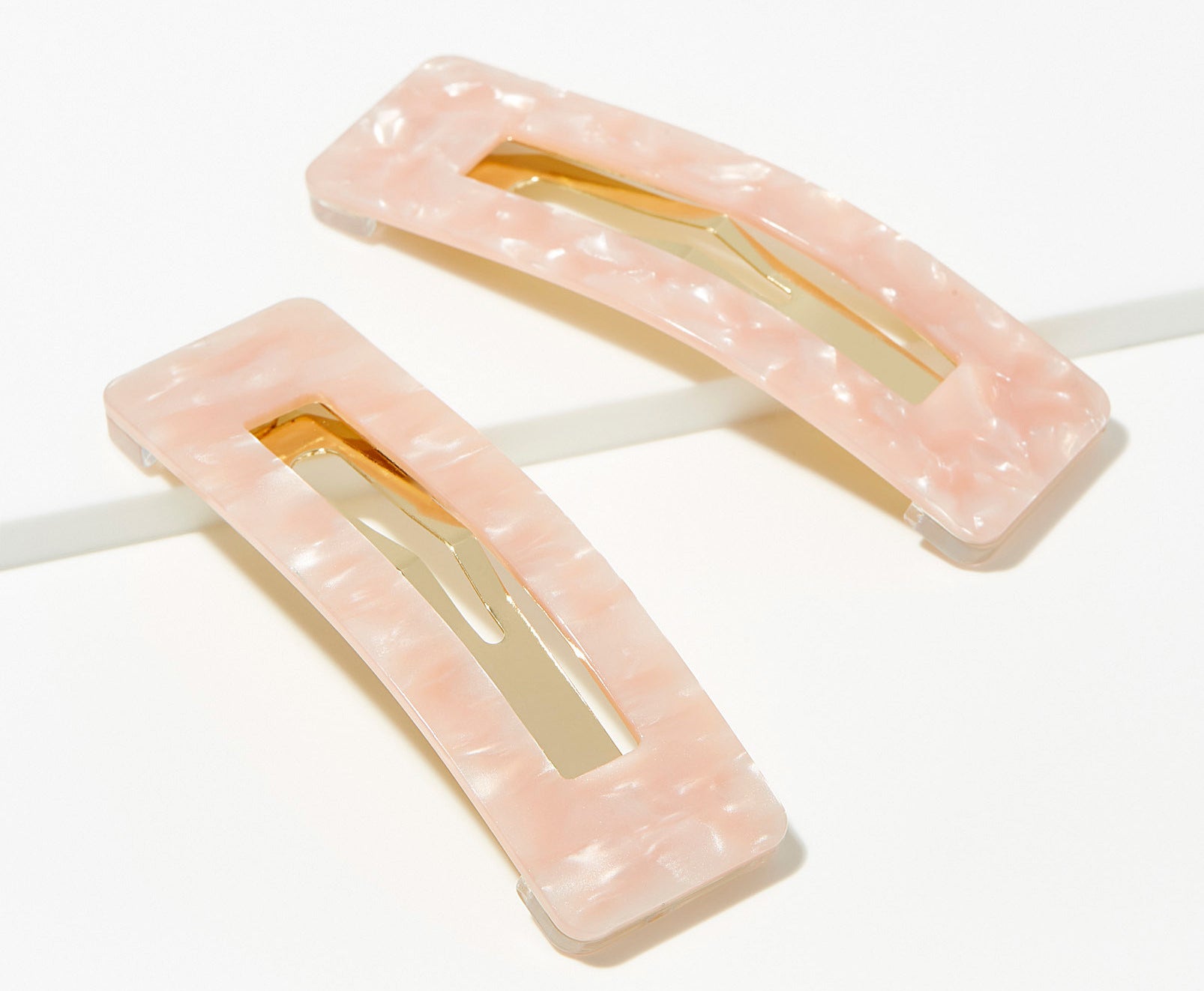 A pair of pearly rectangular clips 