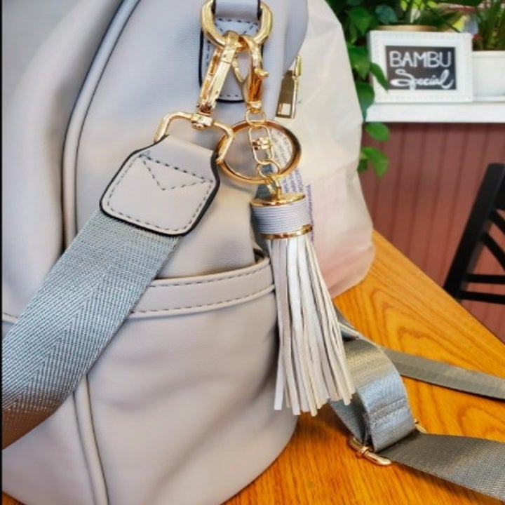 gray backpack with a tassel detail