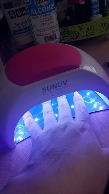 A reviewer with her hand in the UV lamp drying their nails
