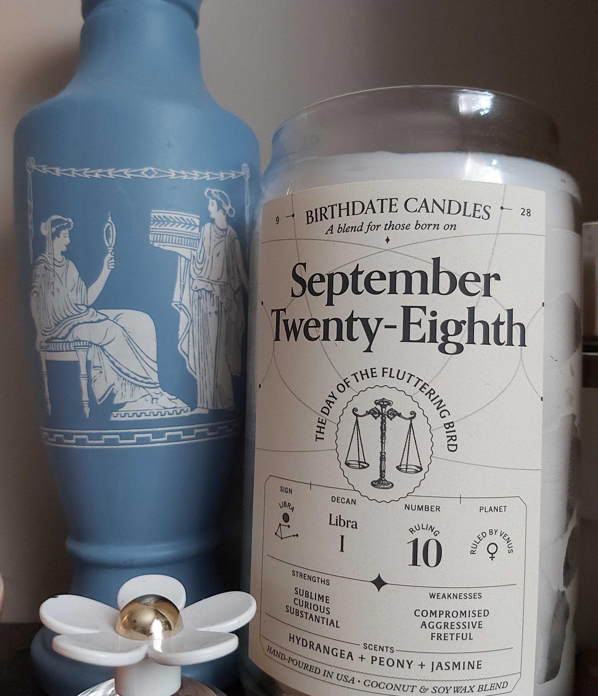 buzzfeeder&#x27;s candle in a jar that says &quot;september twenty-eighth, the day of the fluttering candle&quot; with small astrological sign details for that date