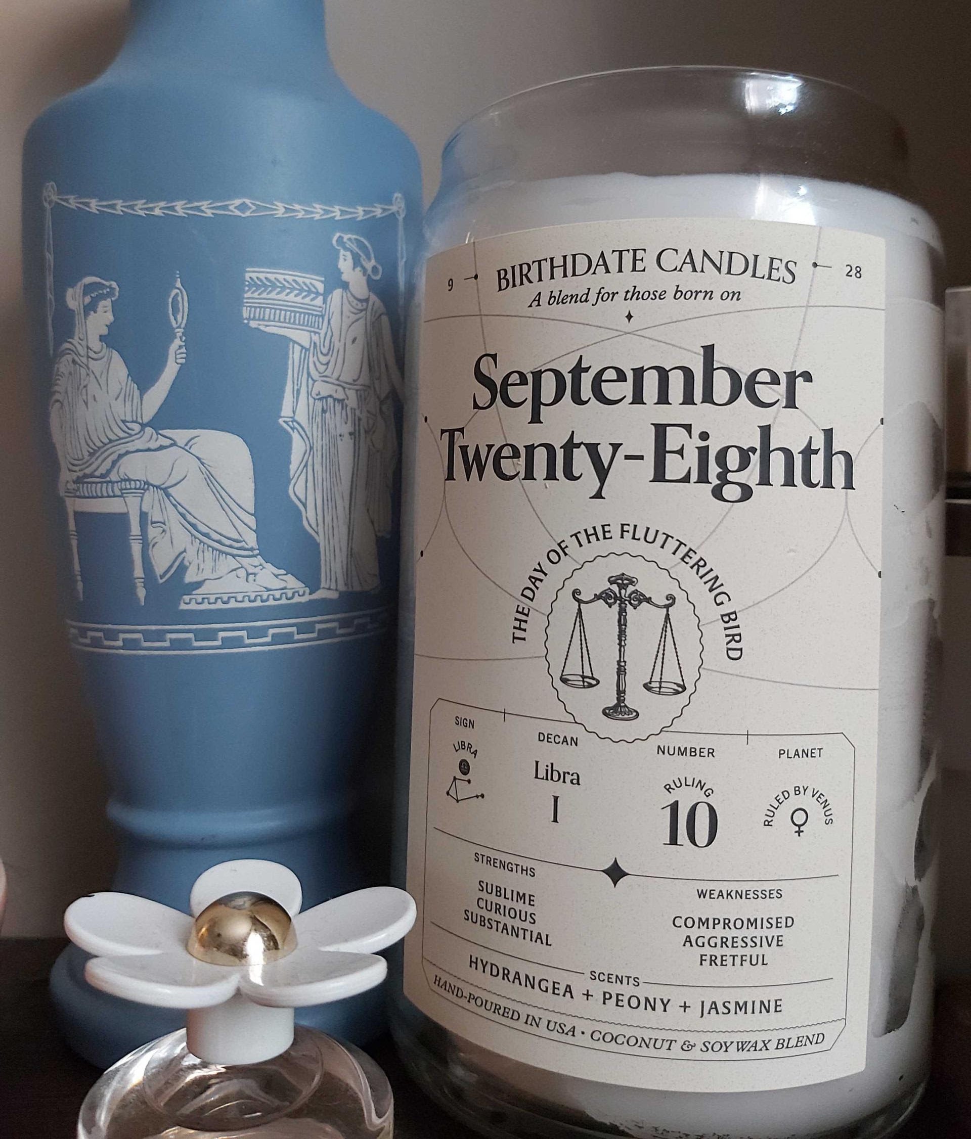 buzzfeeder&#x27;s candle in a jar that says &quot;september twenty-eighth, the day of the fluttering candle&quot; with small astrological sign details for that date