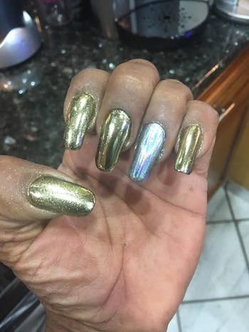 A reviewer showing off their nails with the colors champagne gold and laser silver