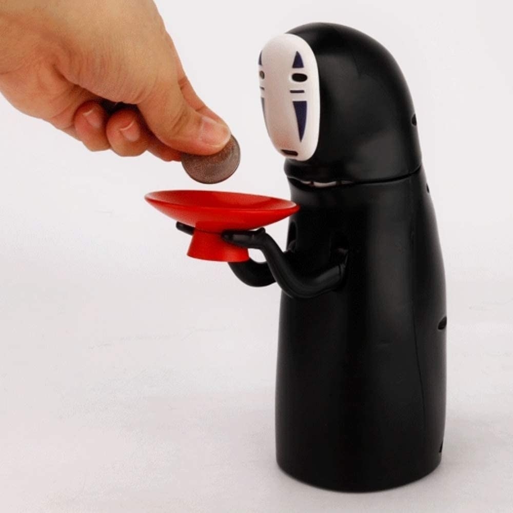 person putting a coin in the plate of the no-face piggy bank