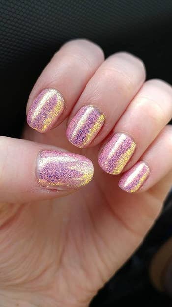 Reviewer showing off nails with a glittery pink color