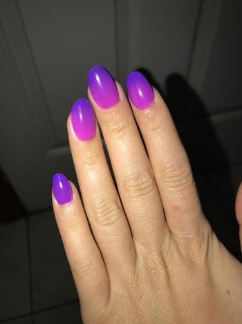 Reviewer showing off purple painted nails with no chips or smudges