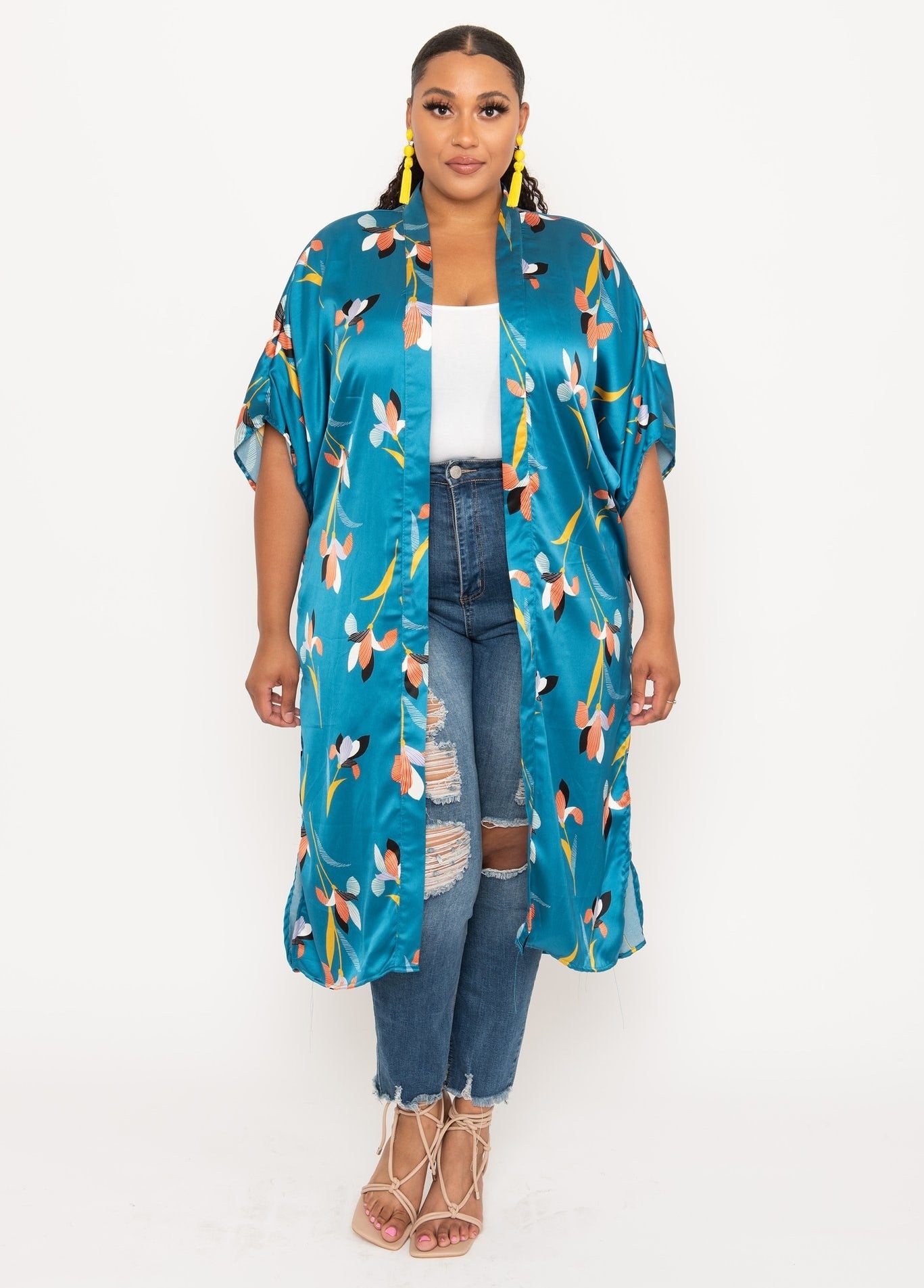 a model wearing jeans, a white t-shirt and a printed silky duster that goes below the knees