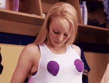 Regina George pulling on her shirt with two holes cut in it to show off her bra