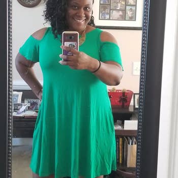 Reviewer wearing green cold-shoulder dress