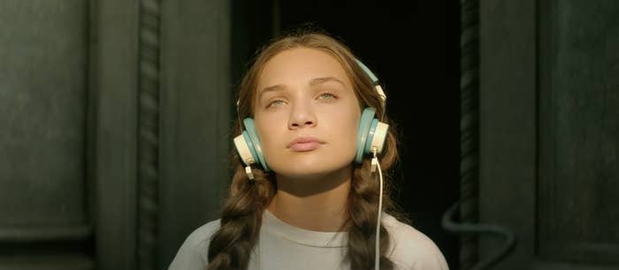 Maddie Ziegler's character sits on the steps listening to music