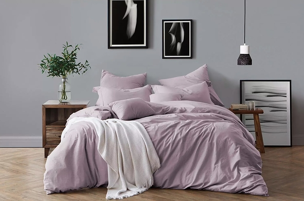 The cotton bedding set in dusty lavender next to two mismatched nightstand