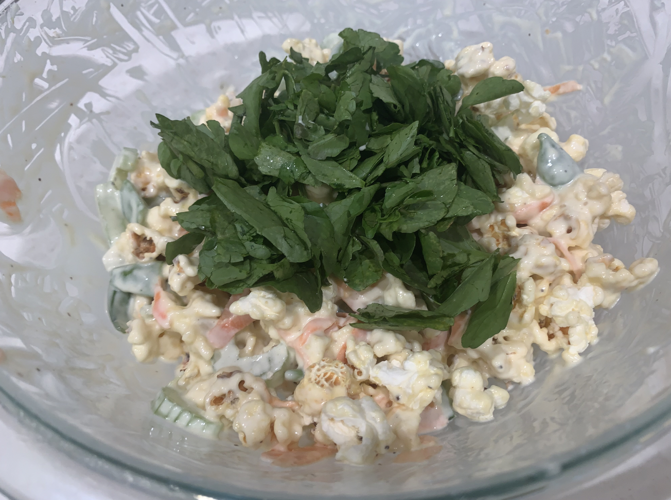 Bowl with the popcorn mixed into the dressing and veggies